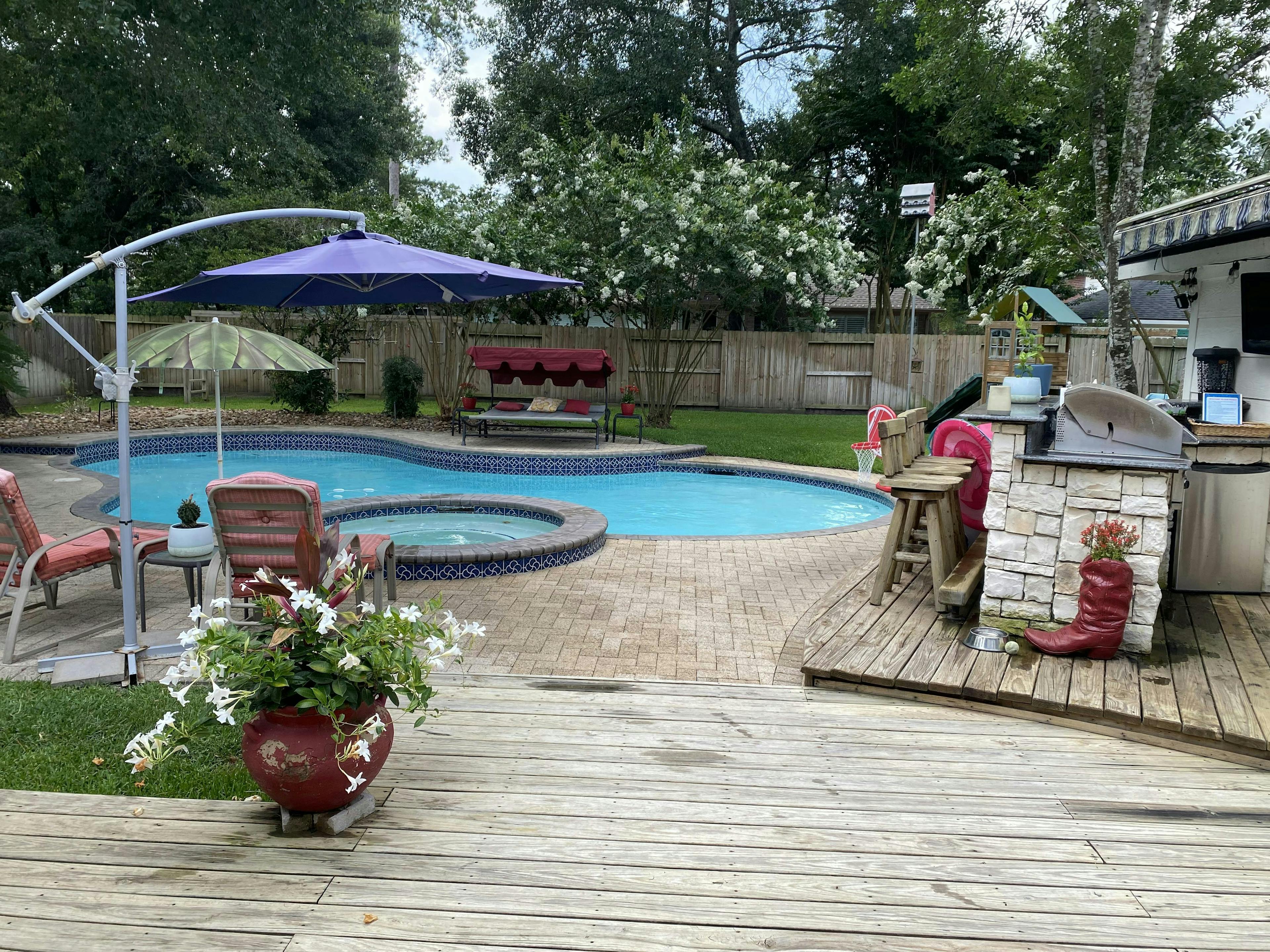 Backyard pool oasis with grill, play set, & hammock